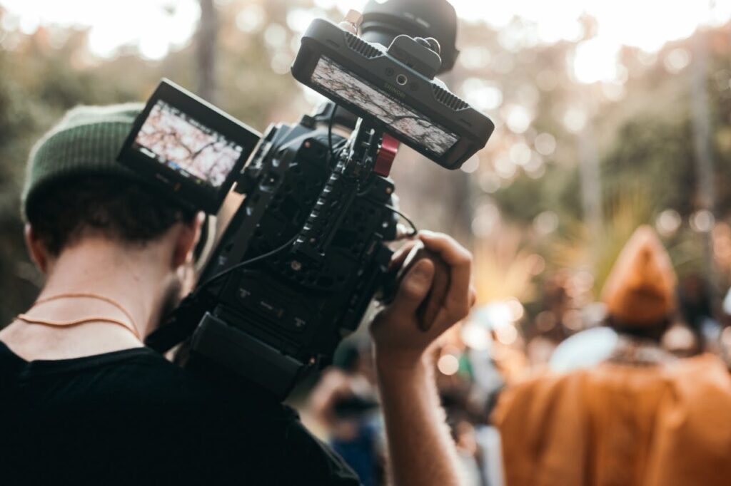 Back View of a Person Holding Black Dslr Camera